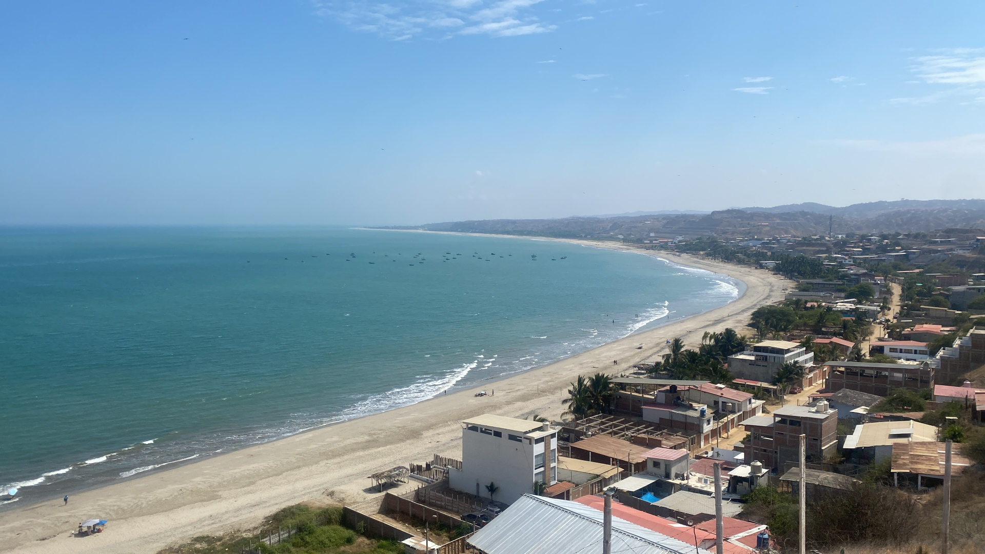 Aerial view of Zorritos coastal bay with artisanal fishing vessels and shoreline community